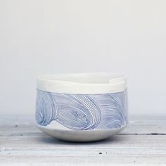 a blue and white bowl sitting on top of a wooden table