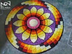 a colorful rug is on the floor with an artistic design in the shape of a flower