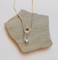 A striking crystal strung through slim heavily-plated 18kt gold chain, creating a daily space for self-care and wellness no matter what is on your plate. A statement making piece to wear alone, or layer up two or three for a unique and mindful look! Genuine Clear Quartz crystal point Point Approx 35mm length, 15mm width As with natural stones, each will vary in color and size 18k gold extra heavy plated Brass base Tarnish-free coating Made in United States of America Thank you for supporting Ame Everyday Gold Spiritual Crystal Necklace, Everyday Spiritual Gold Crystal Necklace, Gold Spiritual Crystal Necklace For Everyday, Minimalist Pendant Crystal Necklace For Meditation, Minimalist Crystal Pendant Necklace For Meditation, Spiritual Gold Crystal Necklaces For Layering, Gold Crystal Necklaces With Delicate Chain For Everyday, Minimalist Crystal Necklace For Healing, Gold Crystal Necklace With Delicate Chain For Everyday