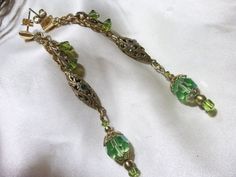 Hand made, these Antique emerald green and lime faceted crystal beads are just sparkling with carnival color! They are beautifully paired with these vintage brass filigree elongated beads that I have set with gemstones of various colors. They are dangling from 14 k gf post earrings with triangular post push backs. They are approx. 2 and 3/4 inches long. Pretty earrings  for a green eyed gal! Gift wrapped year round! Elegant Lime Green Beaded Jewelry, Green Beaded Chandelier Earrings For Wedding, Green Czech Glass Jewelry With Dangling Beads, Green Dangle Earrings Costume Jewelry, Green Dangle Costume Jewelry Earrings, Green Dangle Jewelry With Faceted Beads, Green Crystal Drop Earrings With Dangling Beads, Green Jeweled Chandelier Earrings As Gift, Green Jeweled Chandelier Earrings For Gift