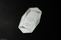 a white business card sitting on top of a black surface