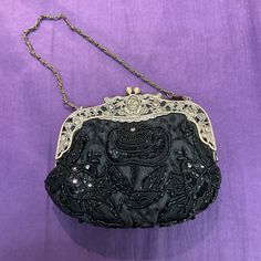 "This gorgeous vinta de  evening bag has a heavy antique gold ornate floral frame studded with rhinestones with a twin top clasp set with rhinestones and a short chain handle. It is made from slightly padded black satin and is decorated on the front and back  in a floral design with seed beads, sequins and rhinestone crystals. It has an oval base and is fully lined with black satin and has an internal pocket.  Measures 7\" x 6\" x 4\" base and remains in excellent vintage condition, a perfect ba Embellished Handheld Evening Bag For Formal Occasions, Glamorous Beaded Evening Bag For Formal Occasions, Glamorous Beaded Evening Bag For Formal Events, Black Embellished Evening Bag, Elegant Silver Evening Bag For Vintage Events, Elegant Clutch Evening Bag For Vintage Events, Elegant Rectangular Clutch For Vintage Events, Rectangular Embellished Evening Bag, Formal Handheld Beaded Clutch