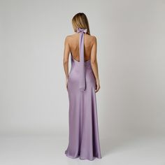 A captivating blend of elegance and allure, our Lylia Open Back Halter Dress exudes undeniable charm. Tailored with a flattering bias cut from lavender double silk satin, it drapes gracefully over the silhouette. The halter neckline delicately frames the shoulders, while the revealing back adds a note of sensuality. For a playful and feminine look, you can transform the silk tie neck into a chic bow, or you can let it drape loosely, adding a touch of laid-back sophistication to your ensemble.  W Elegant Lavender Party Dress, Lavender Evening Dress With Fitted Bodice, Elegant Purple Midi Dress With Fitted Bodice, Chic Lavender Midi Dress For Evening, Elegant Lavender Maxi Dress For Evening, Elegant Lavender Midi Dress For Party, Elegant Purple Maxi Evening Dress, Elegant Purple Maxi Dress For Cocktail, Formal Lavender Dress With Fitted Bodice