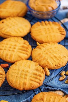 several peanut butter cookies cooling on a wire rack with nuts and other items around them