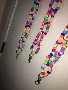 there are three necklaces made out of candy beads hanging on the wall next to a door