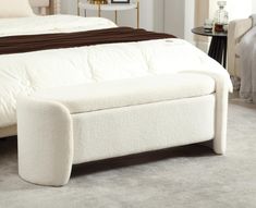 a large white bed sitting on top of a carpeted floor