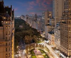 an aerial view of the city at night with tall buildings and street lights in the foreground