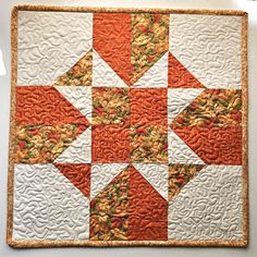 an orange and white quilted wall hanging