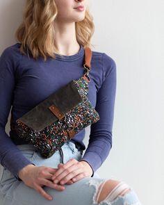 a woman sitting on top of a wooden bench holding a purse over her shoulder and looking off to the side