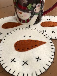 two coffee mugs sitting on top of a wooden table next to a cup holder