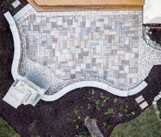 an aerial view of a patio with a bench and fire pit in the middle of it