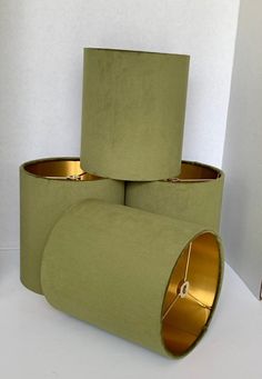 three green lamps are stacked on top of each other in the shape of cylinders