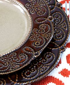 a close up of two plates with silverware on a red and white table cloth