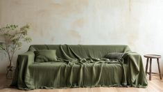 a living room with a couch covered in a green blanket