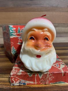 a santa clause figurine sitting on top of a box