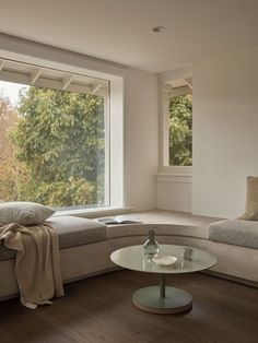 a living room filled with furniture next to a large window covered in windowsills