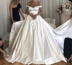 the bride is getting ready to walk down the aisle in her wedding dress, while three other women look on