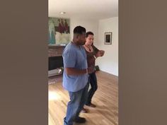 two men are dancing in the living room