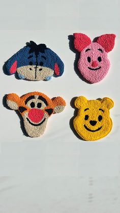 four winnie the pooh hair clips on a white surface, one has a face and two have ears