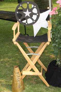 a director's chair sitting in the grass next to a potted plant