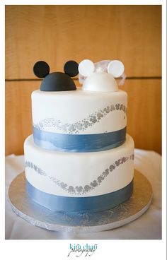 a three tiered cake with mickey mouse on top