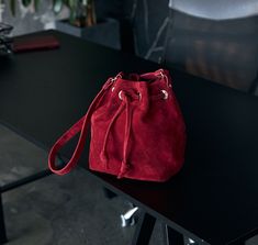 Red Suede Pouch, an elegant and stylish accessory that will add a touch of sophistication to your everyday look. This stunning red suede pouch bag is crafted with precision and care, ensuring top-notch quality and durability. The rich crimson hue exudes a sense of luxury and allure, making it a true statement piece. Perfectly sized to hold your essentials, this pouch is ideal for carrying your phone, keys, wallet, or cosmetics. The soft and velvety texture of the suede adds an extra layer of elegance and comfort. Handmade with love, this red suede pouch is a must-have accessory for any fashion-forward individual. Materials: Red Suede Dimensions: length*height*width 30cm*40cm*10cm The length of the handle is made individually. You can choose the color you want for each bag: - cherry - beige Modern Formal Bag With Suede Lining, Elegant Suede Bucket Bag, Evening Shoulder Bag With Suede Lining, Formal Suede Bags With Suede Lining, Luxury Suede Bucket Bag, Red Leather Clutch Pouch, Elegant Red Travel Pouch, Formal Suede Bags, Red Evening Bucket Bag With Dust Bag Included