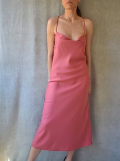 "Slip midi dress with adjustable criss cross back straps featuring a cowl neck in pink berry color. Mid calf length. Lightweight non-stretchy fabric. Model is (172 cm - 5'8\") and (53 kg - 117 lbs) and is wearing size S Handmade in Bali Composition: 100% Viscose" Spring Fitted Slip Dress With Cowl Back, Spring Bias Cut Dress With Cowl Back, Spring Party Midi Dress With Cowl Back, Spring Dress With Bias Cut, Spring Bias Cut Dresses, Spring Slip Dress With Bias Cut And Cowl Back, Summer Midi Dress Bias Cut With Cowl Back, Spring Fitted Midi Dress With Cowl Back, Fitted Spring Midi Dress With Cowl Back