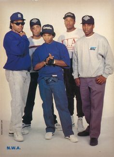 a group of young men standing next to each other in front of a white wall