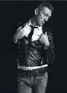 black and white photograph of a man in leather jacket with his hands on his hips