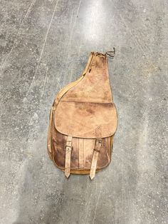 an old leather bag sitting on the ground