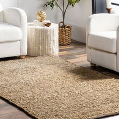 a living room with two white chairs and a rug