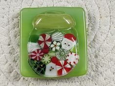 a green tray with assorted buttons in it on a white carpeted surface,