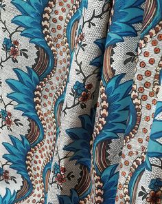 an image of a blue and white fabric with flowers on it's side, close up