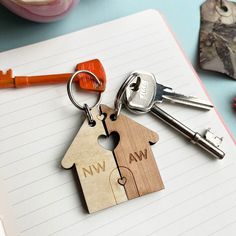 two wooden keychains that have been placed next to each other on top of a notebook