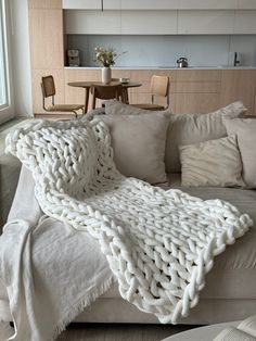 a white blanket on top of a couch in a living room