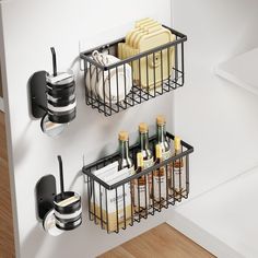 two black metal baskets holding drinks and condiments on the wall next to each other