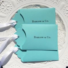 two place cards are sitting on a white plate with ribbons around it and the name barrow & co