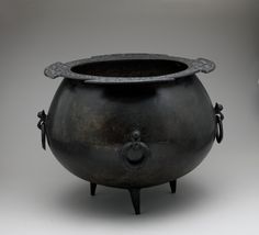 an old black pot is sitting on a table