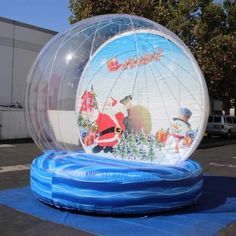 an inflatable christmas decoration with santa claus and snowmen on it is displayed outside