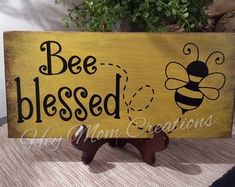 a wooden sign that says, bee blessed and a small statue of a honeybee