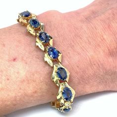 "Here we have an astonishing natural unheated untreated earth mined blue sapphire and fancy natural untreated champagne diamond bracelet in 14K yellow gold circa 1970.  This bracelet is startling to look at firstly because of the bold color contrast of blue and gold and then because of the large size and quality of each of the sapphires. The intense blue sparkle of the untreated sapphires is accentuated further by the generously proportioned wide geometric solid yellow gold links. In each link f Formal Yellow Gold Sapphire Bracelets, Yellow Gold Sapphire Jubilee Bracelets, Sapphire Bracelet With Prong Setting, Luxury Gold Diamond Bracelet With Sapphire, Gold Sapphire Bracelet Fine Jewelry, Gold Sapphire Bracelet In Fine Jewelry Style, Gold Sapphire Bracelets Fine Jewelry, Sapphire Gemstone Diamond Bracelet For Anniversary, Yellow Gold Sapphire Bracelet