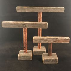 three pieces of wood sitting on top of each other in front of a black background