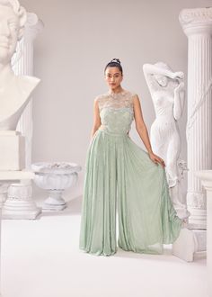 Upgrade your wardrobe with our stunning collection of ethereal couture outfits. The caroline jumpsuit is made with the finest fabrics and crafted with intricate pearl details. This ensemble comprises of a finelly hand embroidered Jacket and a Jumpsuit with a corset further highlighted with alternate kali detailing. Colour: Green Oasis Material: Net- Jacket, Shantley Net- bodice, Opara- kali (jumpsuit), Chinon- kali (jumpsuit) No of components: 2 Surface Ornamentation: Hand Embroidery Care Instructions: Dry Clean Shipping Time: 3-4 weeks Elegant Embellished Sets With Fitted Bodice, Fitted Embellished Jumpsuits And Rompers For Gala, Elegant Sleeveless Jumpsuits And Rompers For Banquet, Fitted Floor-length Jumpsuits For Banquets, Embellished Sleeveless Formal Sets, Floor-length Evening Set With Pearl Embroidery, Evening Floor-length Set With Pearl Embroidery, Elegant Embellished Sets For Gala, Evening Set With Pearl Embroidery And Floor-length Design