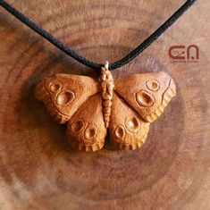 a small wooden butterfly on a black cord