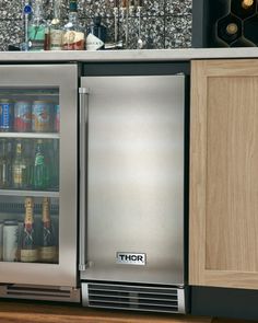 a stainless steel refrigerator freezer sitting inside of a kitchen next to wooden cabinet doors