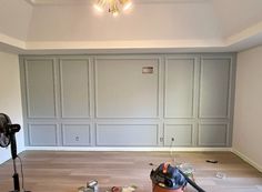 a room with hard wood flooring and walls painted white, including a vacuum cleaner on the floor