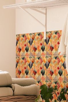 towels are hanging on the rack in front of a wall with orange and yellow tiles