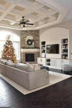 a living room filled with furniture and a christmas tree in the middle of the room