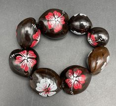 a bracelet made out of glass beads with flowers painted on them