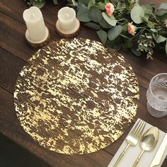 a place setting on a wooden table with silverware and flowers